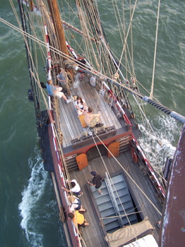 Bird's-eye view of the fore deck as the ship slices through the water.