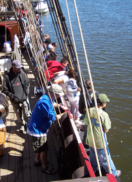 Crew members line the starboard rail to watch the apple core race.