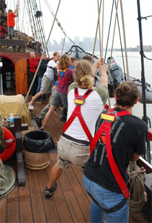 The crew sweats and tails on the tackles to haul the Zodiac onto the weather deck.