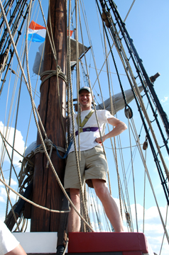 Bram clasps the fore mast as he stands lookout.