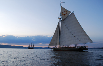 The Clearwater dominates the fram as it sails past, with the Half Moon distant in the background.