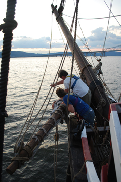 Rachel and Steve furl the spritsail by sunset.