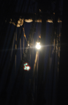 The anchor light hangs from the silhouetted fore mast at dusk.