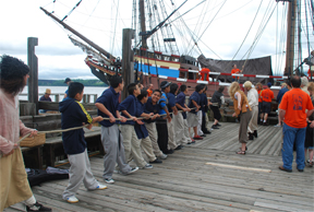 A line of students use a block-and-tackle system to haul cargo aloft.