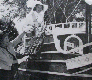 A vintage photo of Gale Brownlee, Miss Henry Hudson 1959, riding a miniature Half Moon parade float.